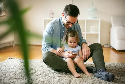 Haus-Familie-Wohnen-Serie-23-20 Vater und Tochter schauen auf Smartphone